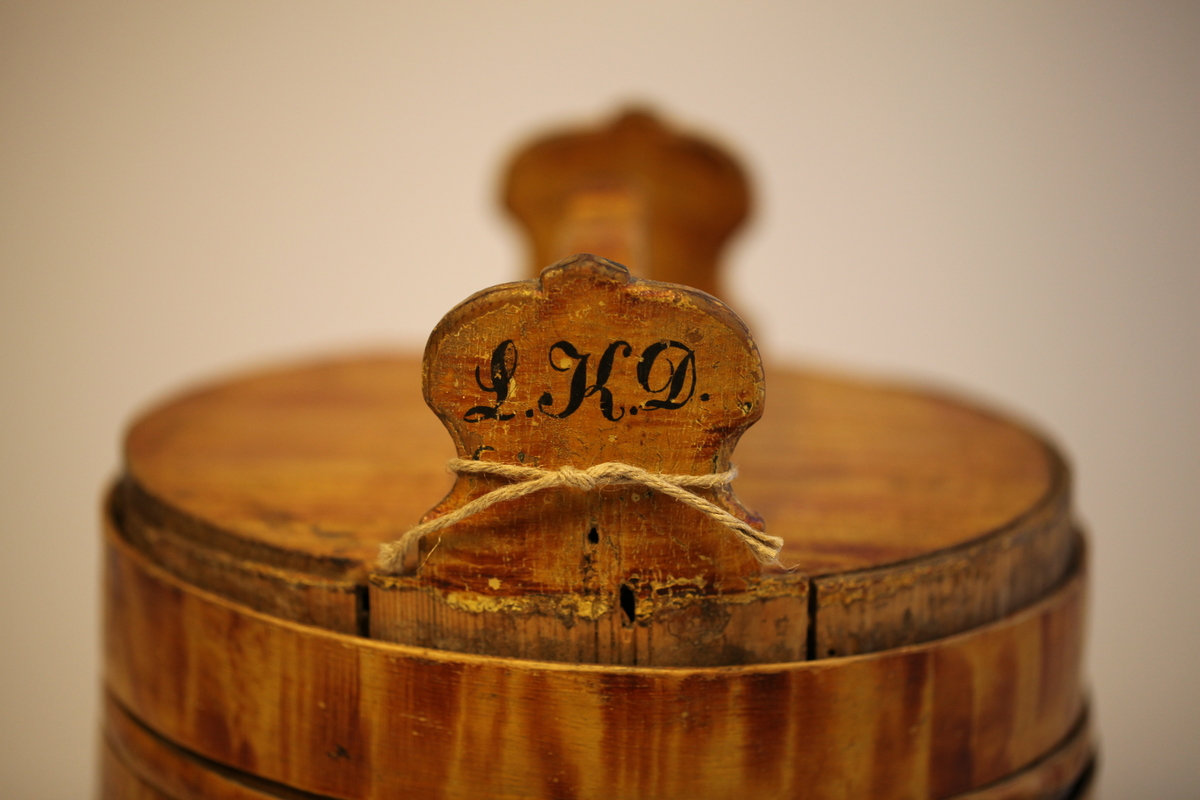 Lagging belagt med tette sveiperinger. Lokk, to ører  og tre bein. Formen er rund, lokk er nedfelt og har avlang hank. Sveip med skjøter (5 stk.) (gjorder). Påmalt gyllengul farge, ådringsmalt.