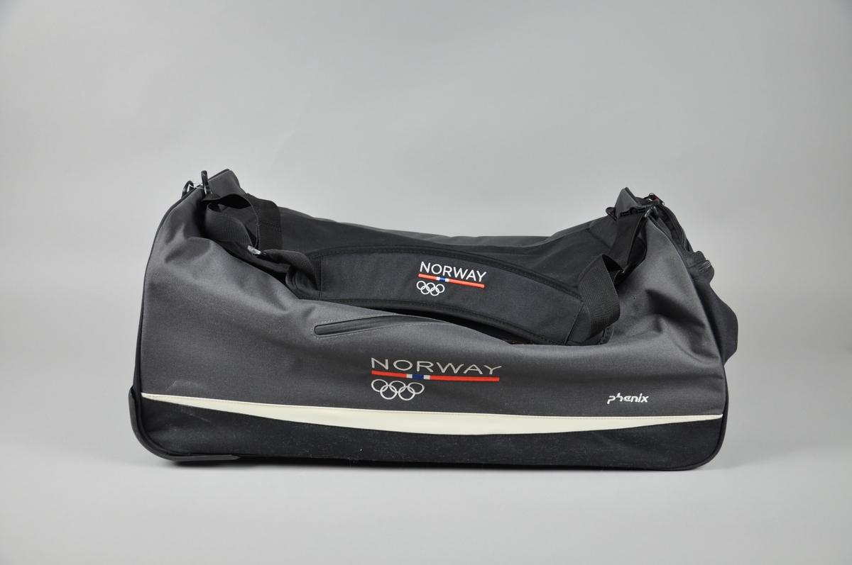 Reisebag med to hjul,bærestropp,bevegelig håndtak.Lukkes med glidelås,to små utvendige lommer som lukkes med glidelås.