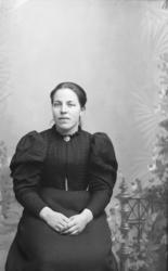 Portrett, kvinne sitter på stol, brystbilde