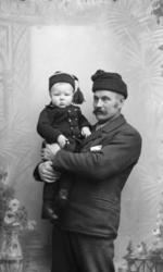 Portrett. Mann med liten gutt på armen. S. Jastad og Sverre 
