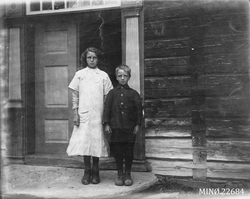 Jente og gutt på trappa til et hus