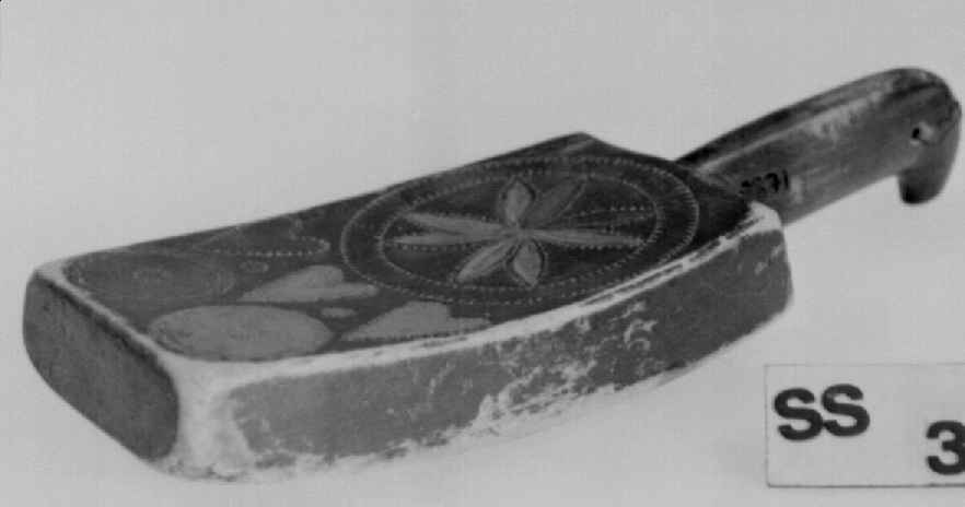 Banketre av ett trestykke med rosett og hjerter malt i blått, gult og rødt. Banketreet er grønnmalt og lite brukt.