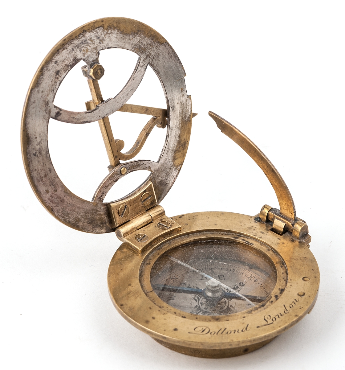 Kompass, av mässing, från Dollond London.
Glaset över kompassnålen är spräckt.
Förvaras i röd skinnask.
