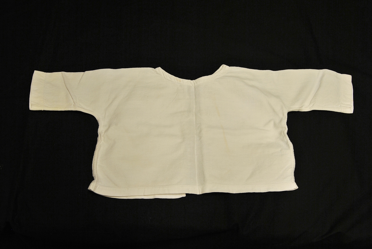 Babytrøye med knytinger bak. Rektangulær i formen.