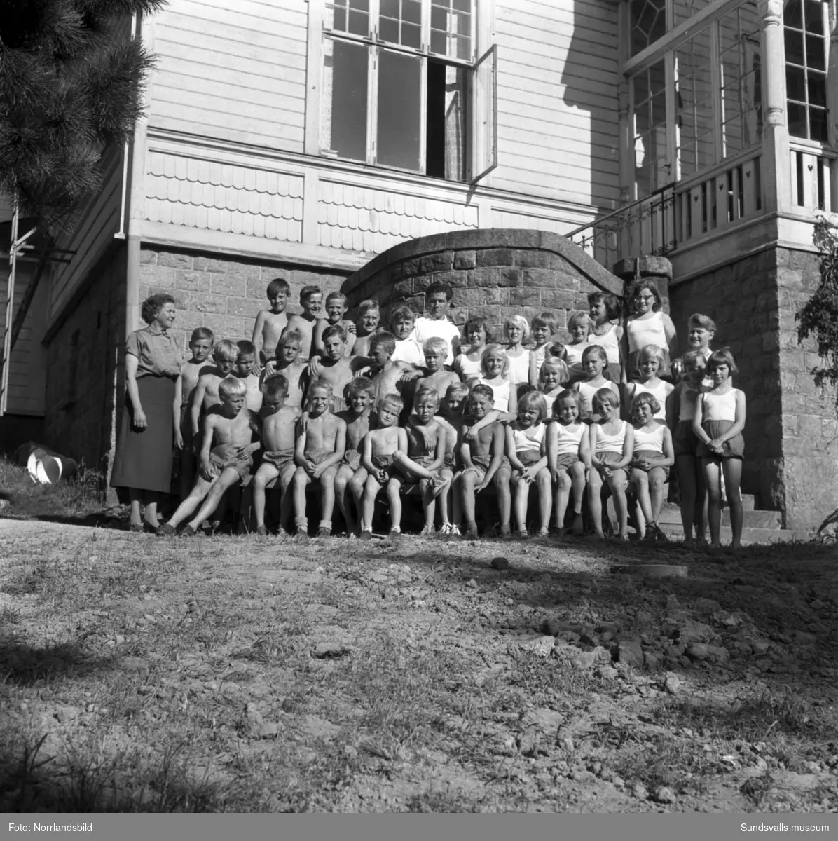 Sommarkoloni vid Karlsviks herrgård med barn från Kiruna på besök. Barn som leker i trädgården och gruppfoton.