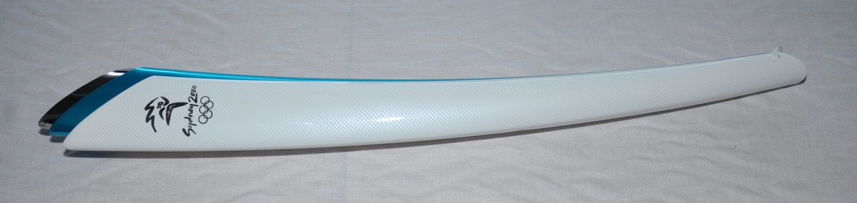 Emblemet for Sydney 2000 øverst på fakkelen, deretter teksten Sydney 2000 og så de olympiske ringene.Fakkelen er inspirert av Sydney Opera House, formen på  boomerangen og det blå for Stillehavet. Designet av Blu Sky Design/GA & Harrington. Brensel var propan og butan.