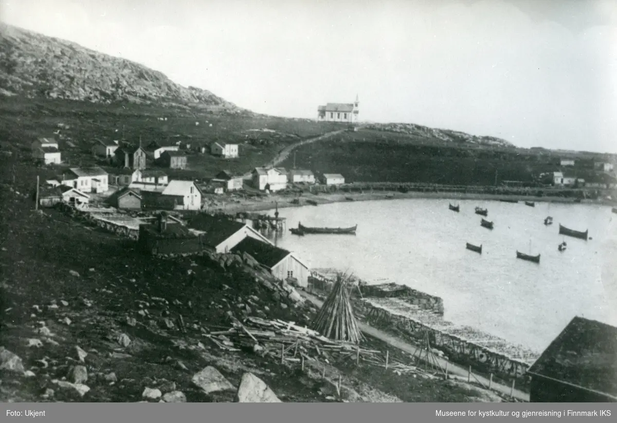 Oversiktsbilde av Honningsvåg. Vågen med den nye kirka og bebyggelsen langs stranden. Ca. 1890.
