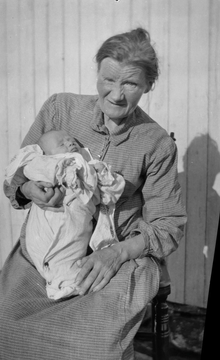 Eldre kvinne med spedbarn.