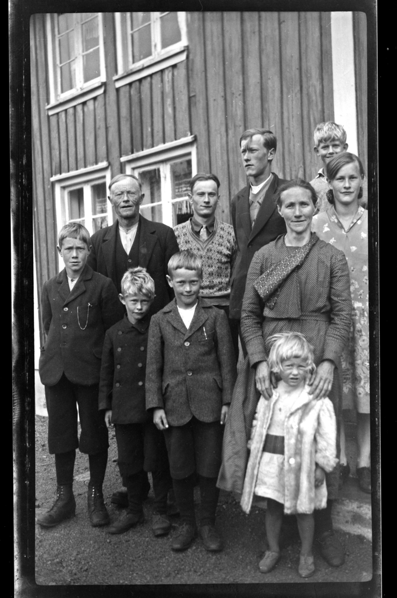 Rolf Sundt Jr. i bakgrunnen sammen med gårdbruker Ånen Loga og familie, Loga i Eiken. Fotografert juli 1932.