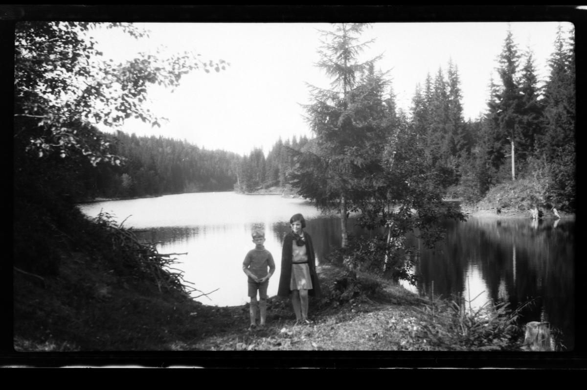 Rolf Sundt Jr. og hans kusine Elsa Sundt foran ukjent skogsvann. Fotografert sommeren 1928.