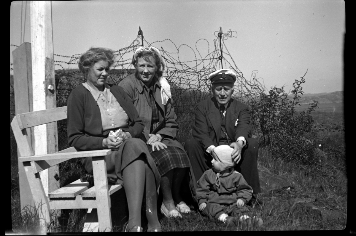 Agnes Sundt og Ingeborg Sundt sitter sammen med Rolf Sundt sr. og Bjørn Sundt ved lysthuset, Loshavn. Fotografert mai 1953.