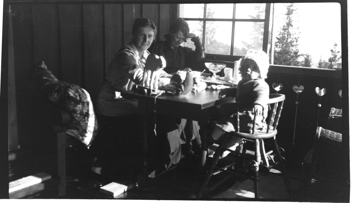 Hilda Sundt spiser sammen med sin svigerinne Sigrid Sundt og sønn ulius Sundt på den vestre verandaen på Villa Knyggen. Fotografert 1918-1919.