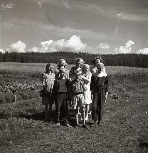 Veckebobarnen, Unga Odlare i Ovanåker, 1950. Några barn har ställt upp sig för en gruppfotografering på en åker.