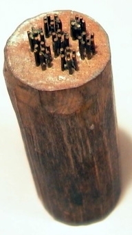 Tryckstock av trä, med mönster av mässingsstift i små grupper.