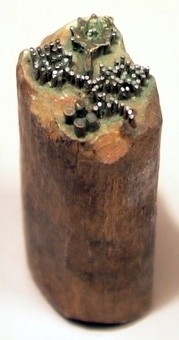 Tryckstock av trä, med mönstertryck i form av en blomkvist av metallstift.