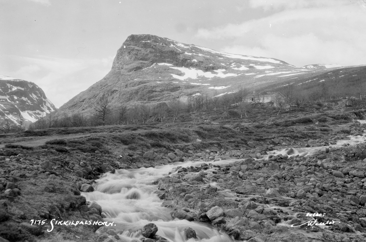 Nord-Fron. Sikkildalshorn i bakgrunnen med Skålbekken og ei tømmerhytte i forgrunnen.