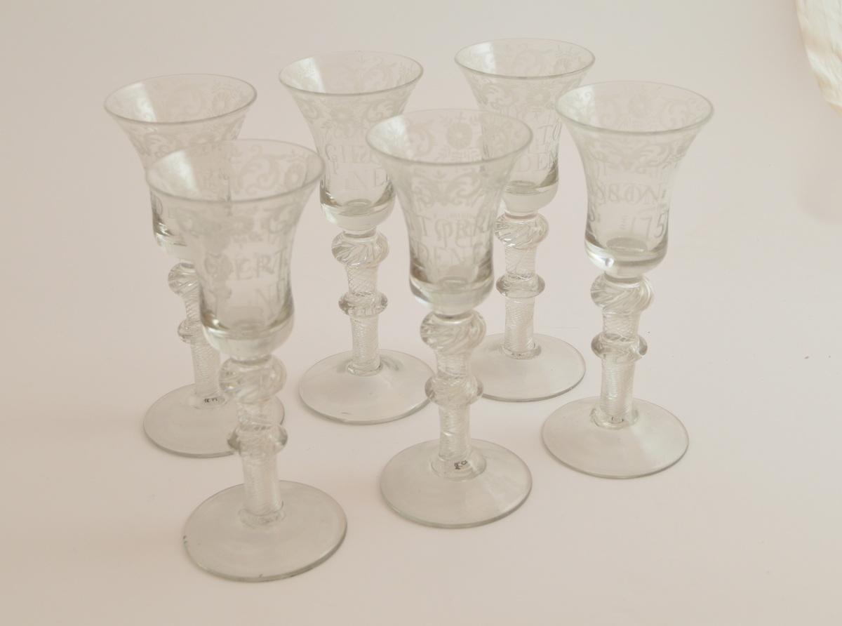 Seks glass. Rund fotplate, to runde former på stettet Klokken er smalnende midt på glasset og videst langs munningsranden.