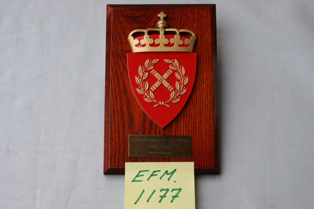 Treplate med merke/logo for Generalinspektøren for Hæren,  og tekstskilt.