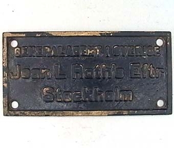 Rektangulär skylt av svartmålad mässing med text i relief.
VGJ Nº 28
SJ B3p 3109 (1948)
HS Nº 19246