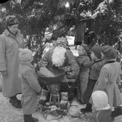 Barn og en frelsesoffiser ved julenissen på Torvet
