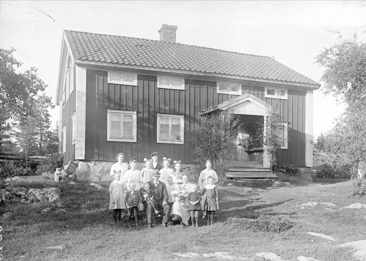Erik Ekström med familj utanför bostaden i Bärtbo, Tärna socken, Uppland 1919