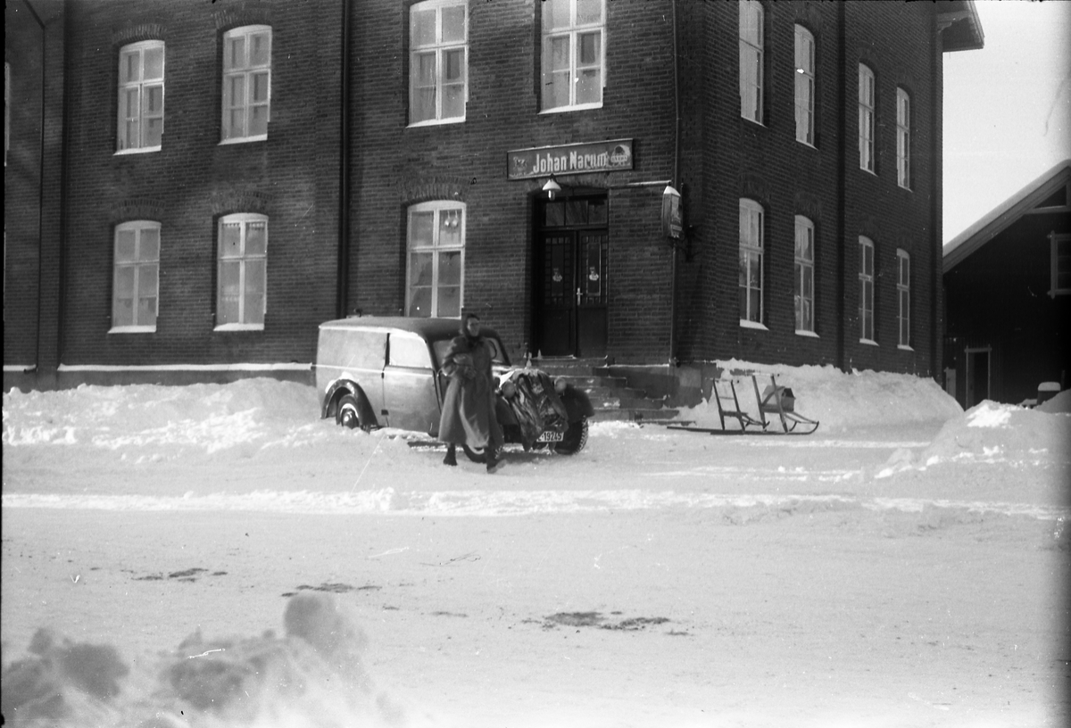 En bil og ei uidentifisert kvinne foran Narums-butikken på Lena ca. årsskiftet 1952-53. Bilen er iflg. informant trolig en førkrigs DKW.