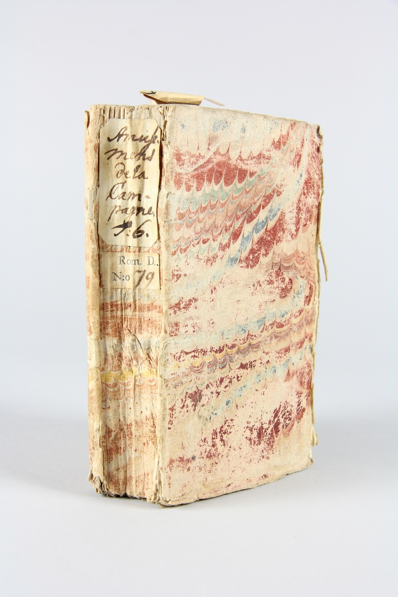 Bok, häftad, "Amusemens de la campagne, de la cour et de la ville", del 6, tryckt 1739 i Amsterdam
Pärm av marmorerat papper, oskuret snitt. På ryggen etikett med  titel och samlingsnummer.