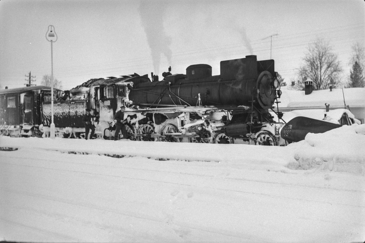 Persontog fra Oslo Ø til Trondheim over Røros, Pt. 301, på Rena stasjon. Toget trekkes av damplokomotiv type 26a nr. 215.
