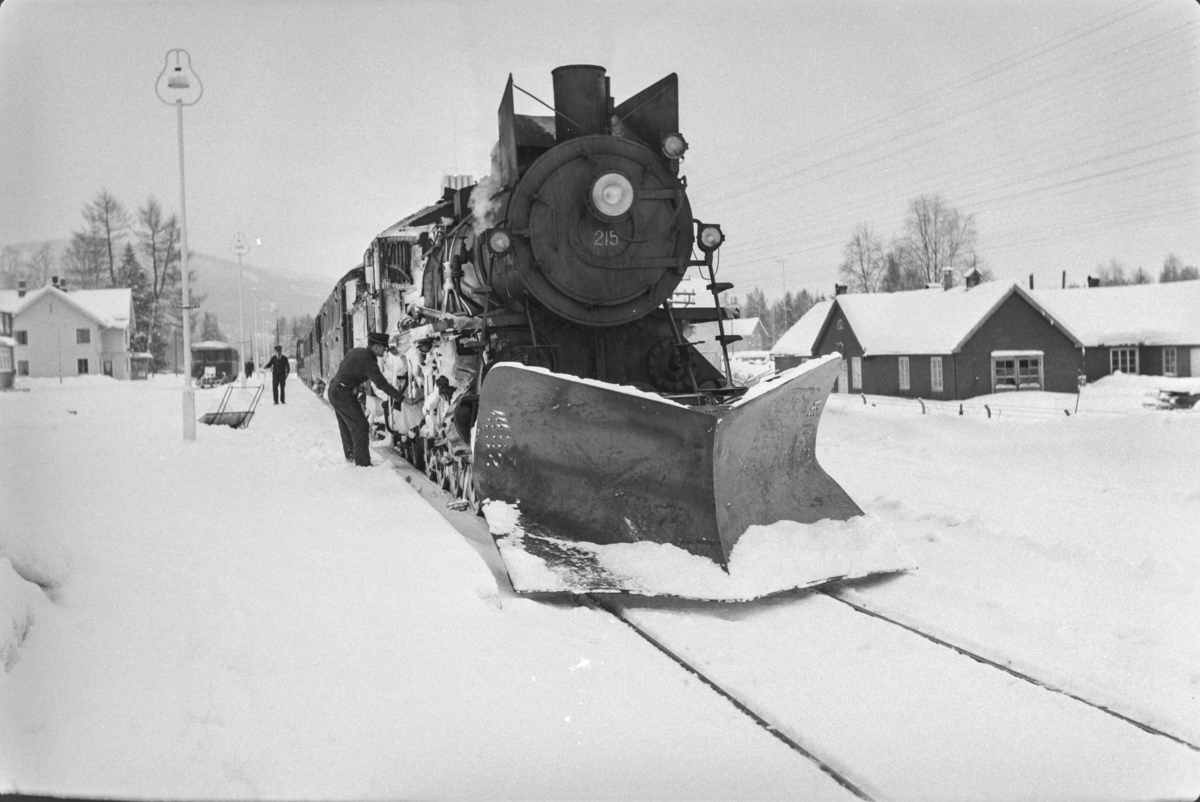 Persontog fra Oslo Ø til Trondheim over Røros, Pt. 301, på Koppang stasjon. Toget trekkes av damplokomotiv type 26a nr. 215.