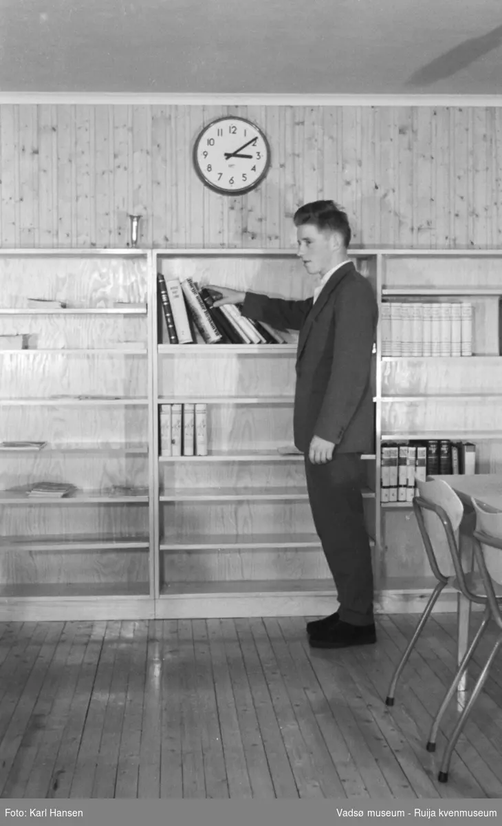 Finnmark Landbruksskole, Tana. I lesesalen/biblioteket.
Skolen gikk først under navnet Fagskolen for Finnmarkens næringsliv.  I 1923 ble navnet endret til Finnmark landbruksskole. I førkrigsårene var det hektisk aktivitet ved skolen, det ble bl.a. reist et nytt internat i 1938. I august 1940 overtok tyskerne. All undervisning ved skolen ble innstillt og høsten 1944 ble bebyggelsen i Tana brent. Først i 1956 var gjenreisningen kommet så langt at det første kullet etter krigen kunne begynne. I 1958 ble arbeidet med det nye undervisningsbygget igangsatt. Inntil dette stod ferdig i 1960, måtte undervisningen foregå i internatbygningen. (www.nsd.uib.no)