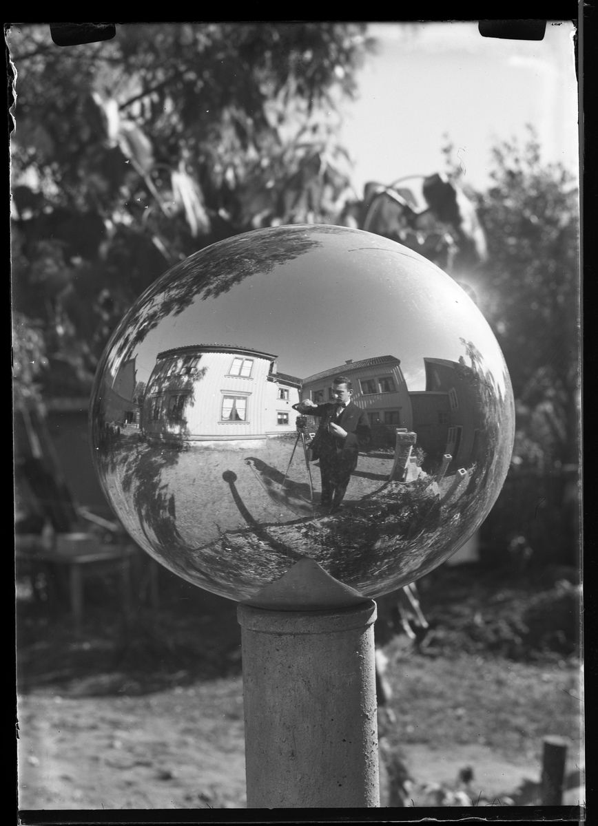 Fotografering av en spegelkula. I kulans reflektion syns Harald Olsson själv. Spegelkulor var en populär detalj att placera i sin trädgård och skapade reflektioner av solljuset.