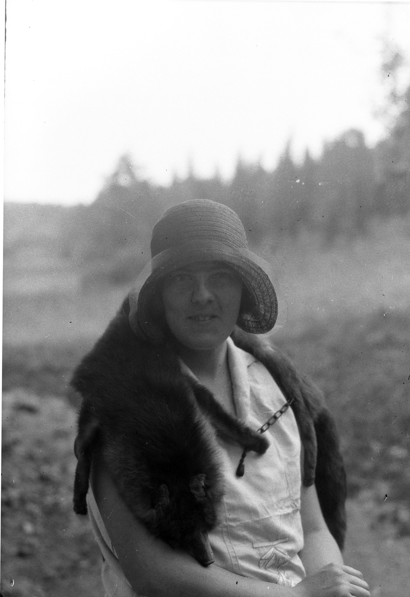 Porträtt av Lizzie Skoglund med en rävboa om axlarna och stråhatt.