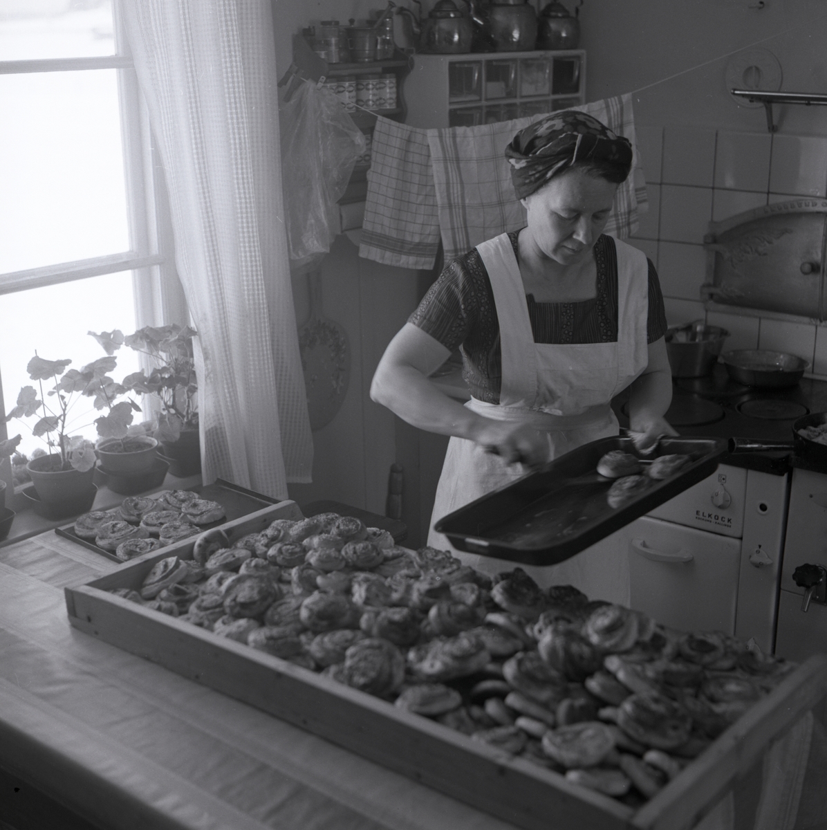En kvinna bakar bullar i köket på gården Sunnanåker, 1967.