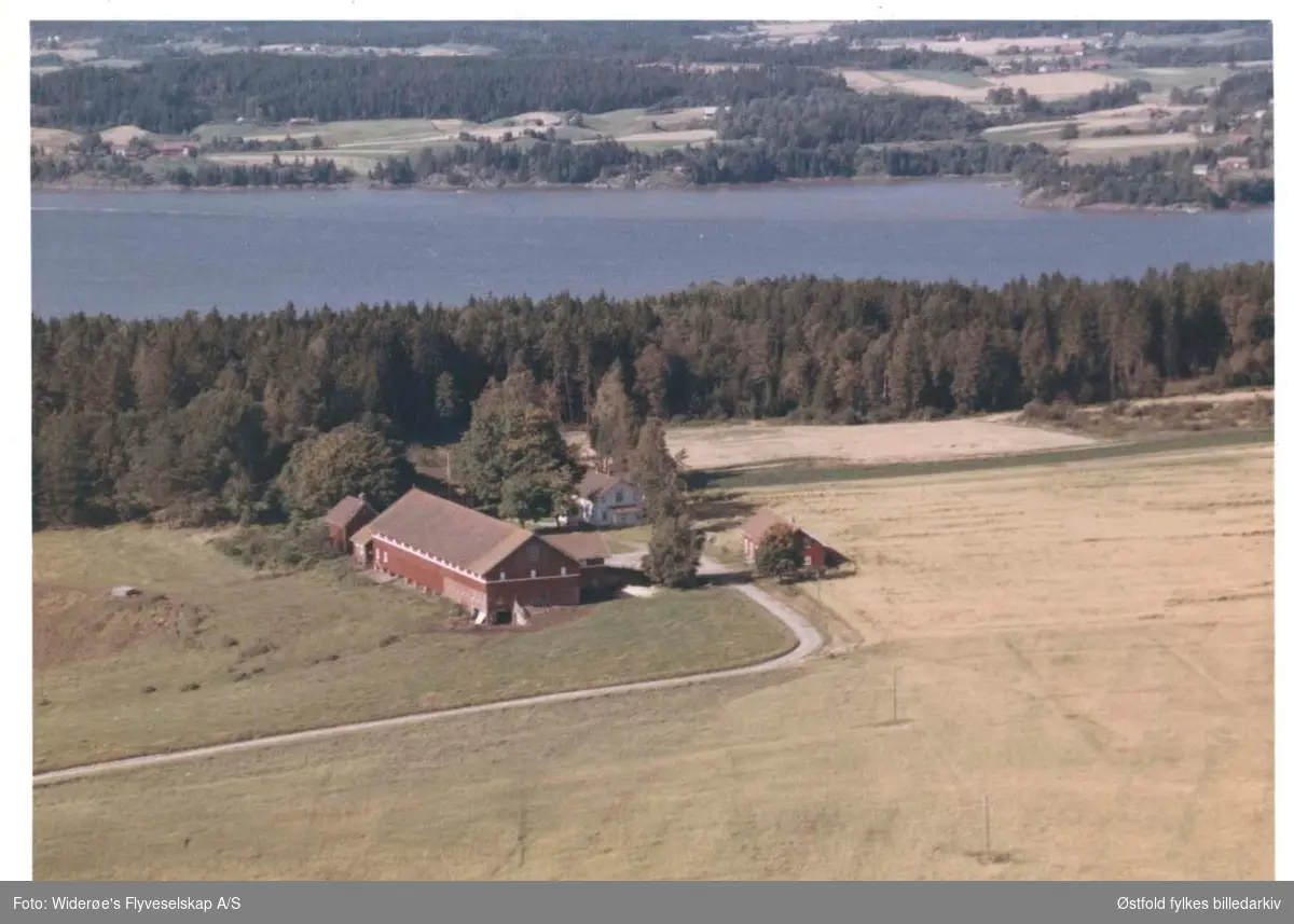 Skråfoto av gården Westby, Rakkestad 11. juli 1963.
Daværende eier var Kristian Westby.
Glomma i bakgrunnen. 
Bredden på den andre siden ligger i Skiptvet kommune.