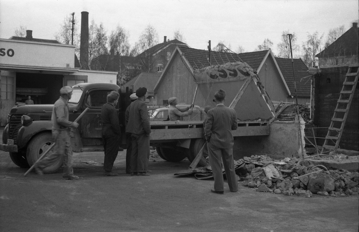 Lasting av rester etter riving av ekspedisjonsbua på Esso på Lena april/mai 1954. Rivinga hadde nok sammenheng med modernisering. Tre bilder. Ingen av personene på bildene er identifisert. Lastebilen er ifølge informant en Fargo 1946/1947-modell.