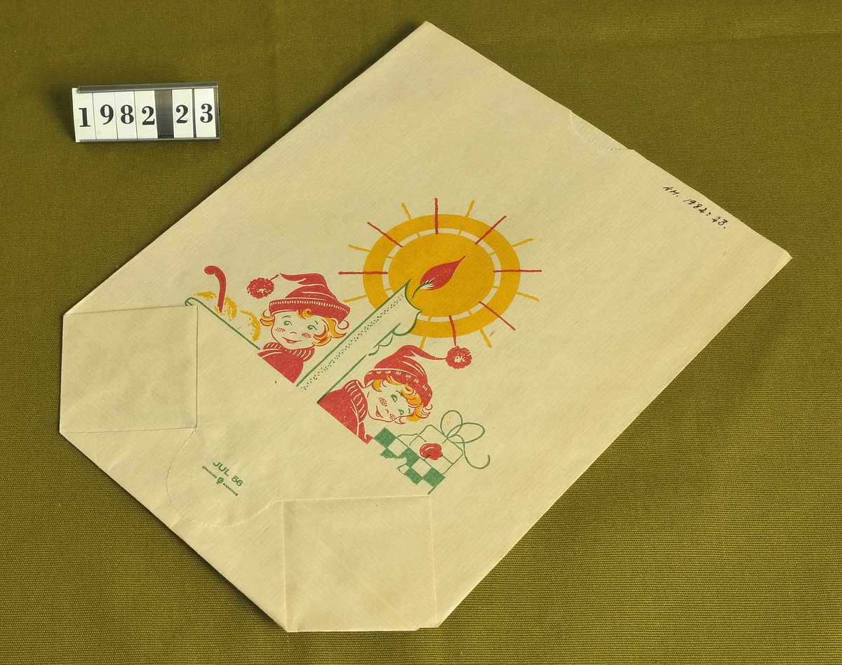 Av vitt papper med julmotiv i färgerna
rött, gult och grönt.

Storlek: 18,5 x 24 cm.
