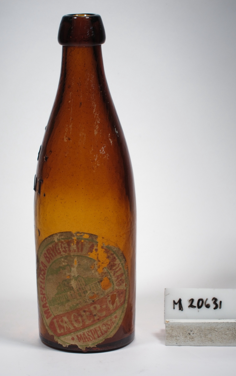 Ölflaska.
Brunt glas.
Etikett med text. Se "Signering, märkning" ovan.
Inskrivet i huvudkatalogen 1968.

Maspelösa bryggeri (1899-1927).
Funktion: Ölflaska