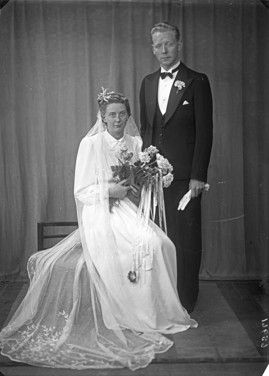 Brudebilde. Ung kvinne i lys brudekjole og ung mann i mørk dress med tverrsoversløyfe. Brudepar. Bestilt av Per Velde. Haraldsgt.