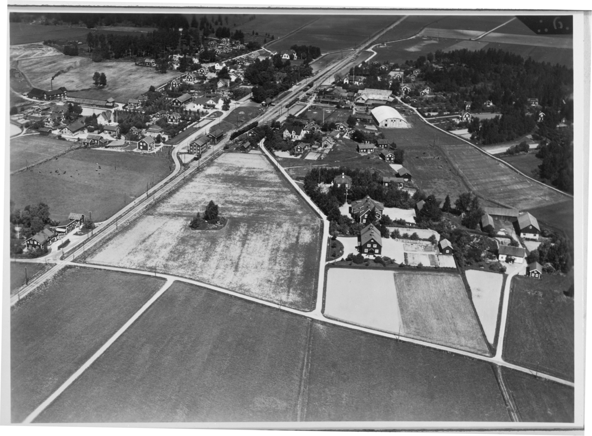 Flygfoto över Österby, Sala,, med folkskolan till höger om mitten.
