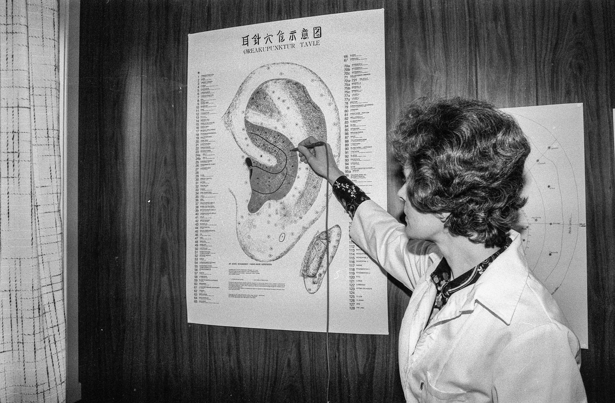 Homeopat Eva Langfeldt i Ski viser plansjer av Øret, kroppen, føtter og fotblad. Peker på punktene.