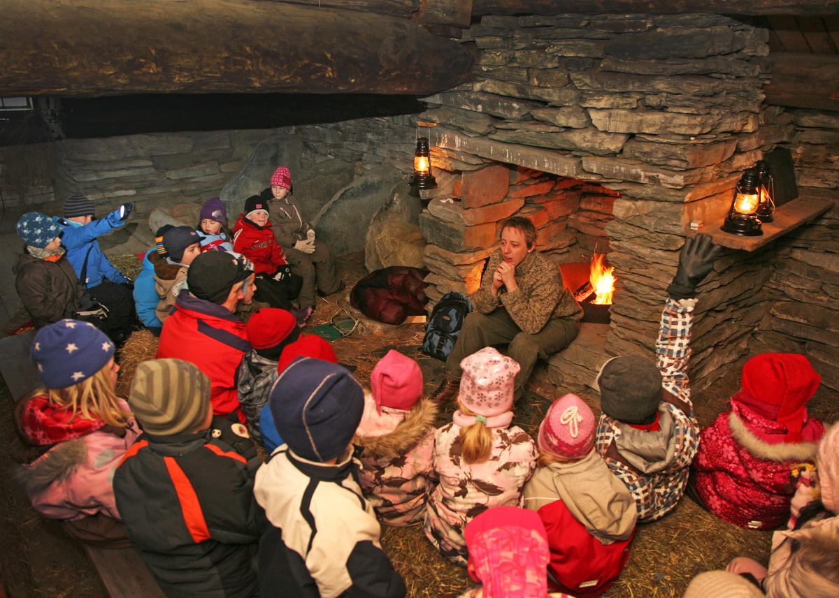 Barn som hører på en fortellerstund i steinlåven, på Tunsettunet, i museumsparken på Glomdalsmuseet.