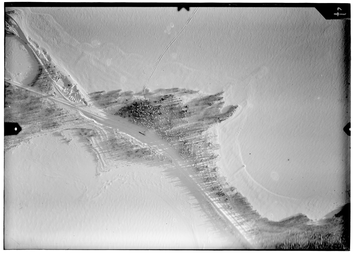 Flygfotografi av landskap av väg och skog på Ajos i närheten av Veitsiluoto under finska vinterkriget 1940. Från F 19, Svenska frivilligkåren i Finland.