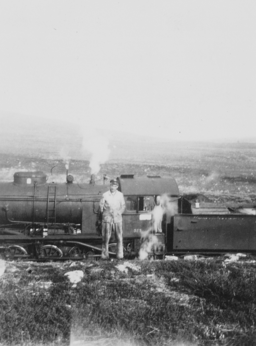 Lokomotivfører John Sverre Røddesnes foran damplokomotiv type 33a nr. 323.