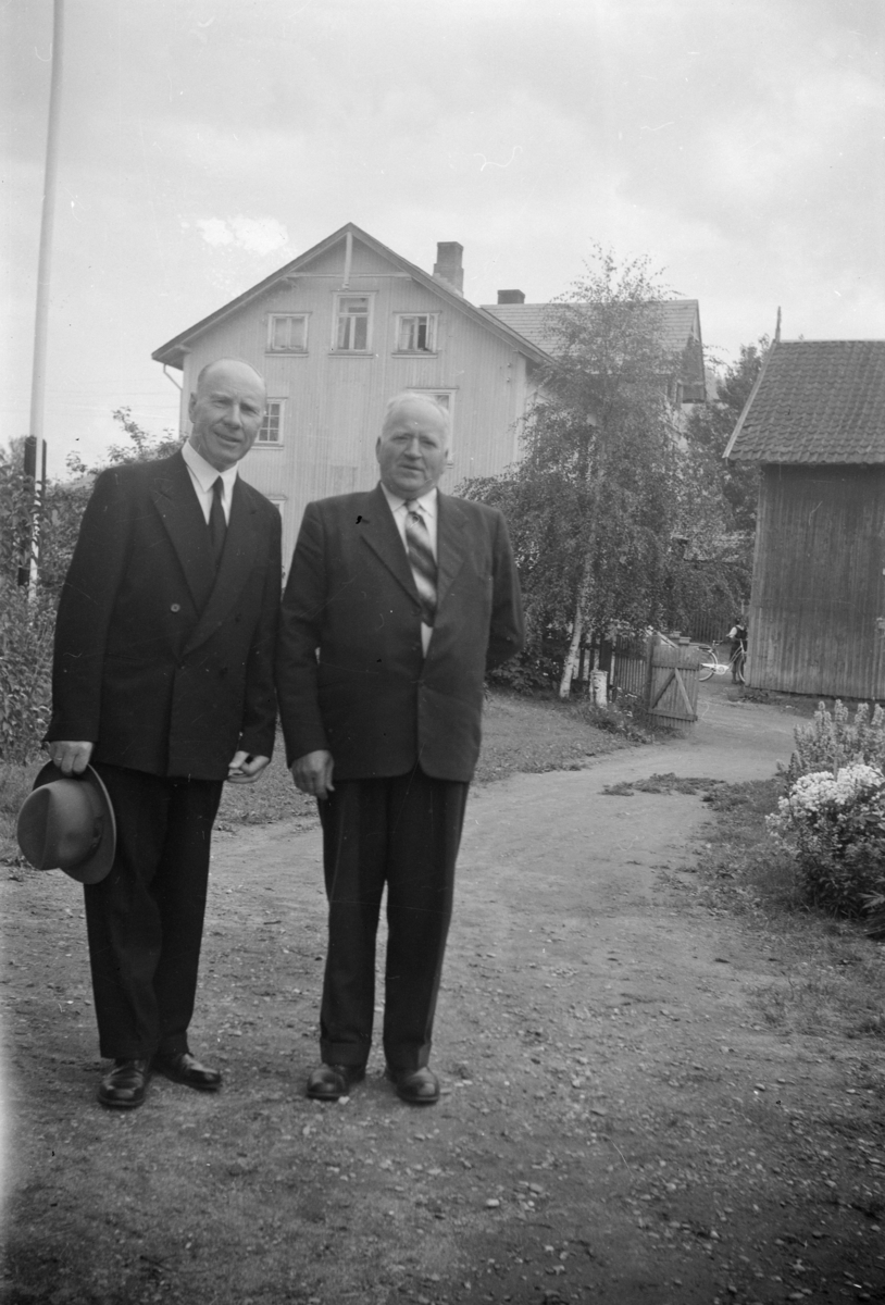 På gårdsplassen til Magnhild og Birger Børresen med Vestre Gausdal handelsforening i bakgrunnen - sogneprest Niels Andberg til venstre og  organist Ottar Rønning