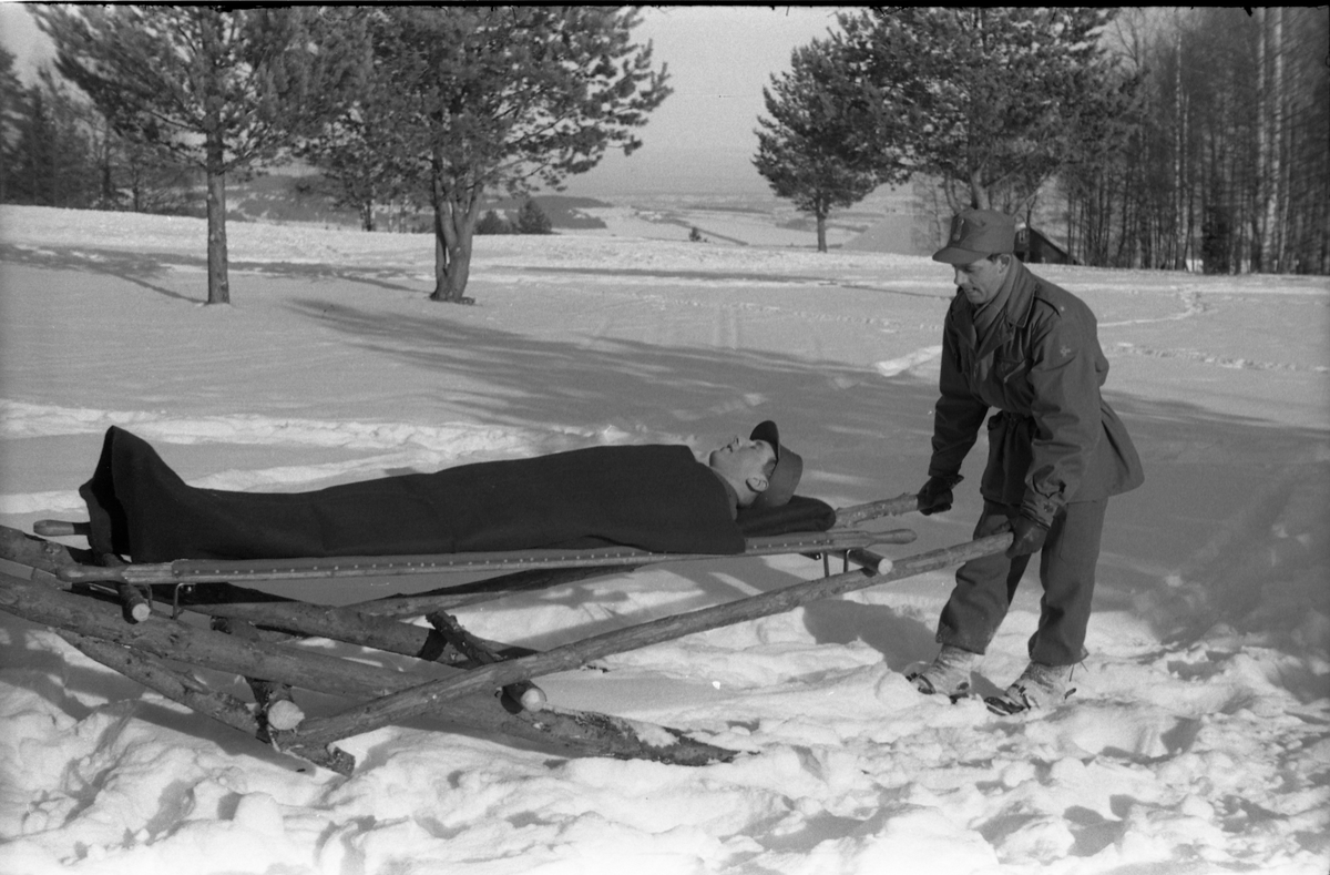 Fire bilder fra Hærens Hesteskole på Starum. vinteren 1955. Improvisert anordning for transport av sykebåre trukket av hest på snøføre.
