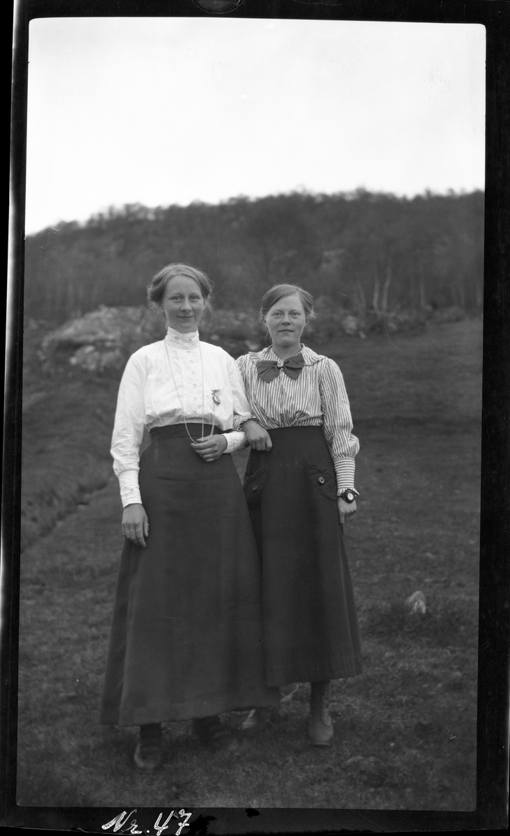 Portrett av to kvinner stående utendørs.