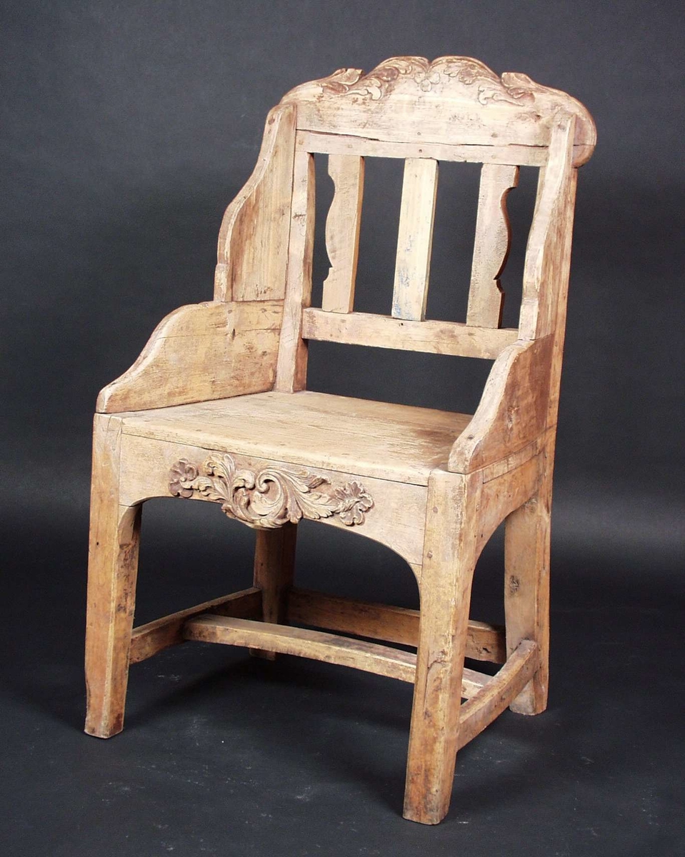 Stolen er av bjørk og har utskjæringer med akantus og rocailler på stolryggen og på framre sarg. Stolen har antagelig vært rødmalt.