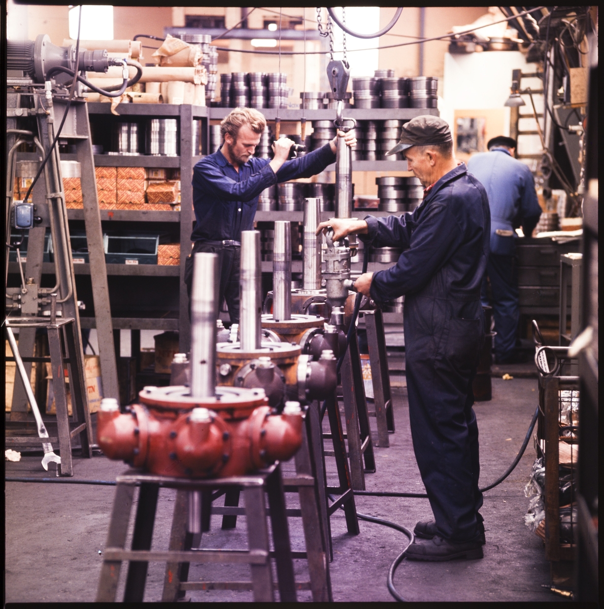 Flere menn arbeider med ulike stålprodukter på firmaet "Brørdrene Bauer-Nilsen A/S".