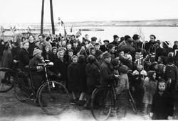 17. mai-tog i Vadsø 1945. Opptog med folk sykler og flagg.