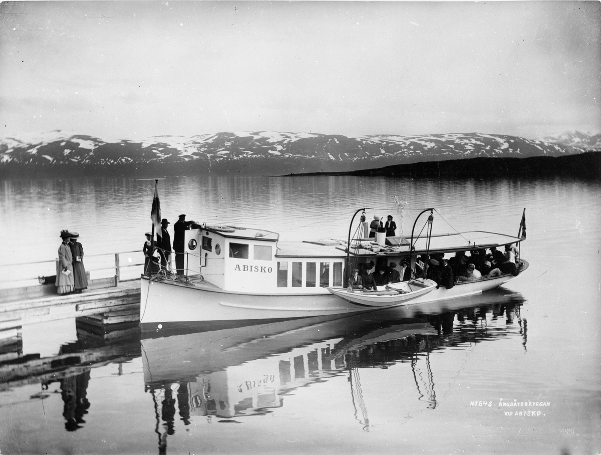 Ångbåtsbryggan med båten Abisko. Från år 1900 gick båtturer med turister över sjön från turiststationen. Ångbåten gjorde sin första tur 1911 och blev en legend under sina femtio år i trafik.